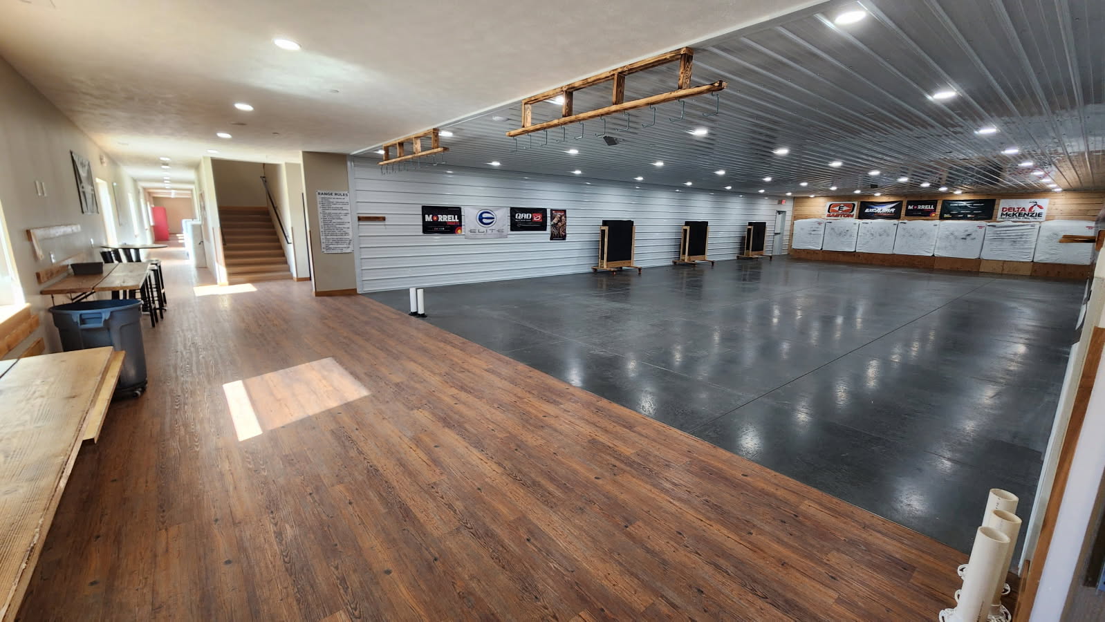 Indoor 20 yard target range with white shiplap walls and brand banners